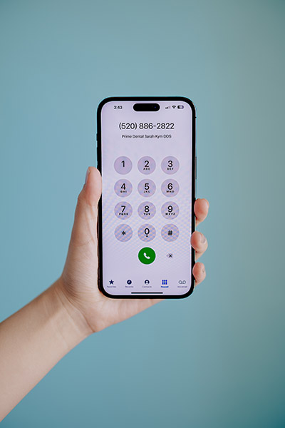 woman making an emergency dentistry phone call on an iPhone