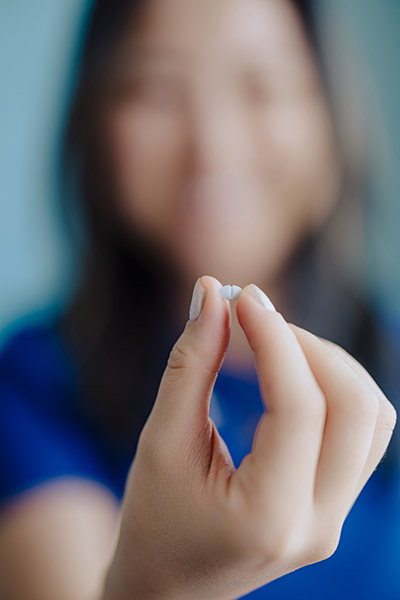 woman holding pill in preparation for oral sedation dentistry